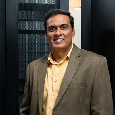 Giri Prakash in front of the Cumulus high performance computing cluster